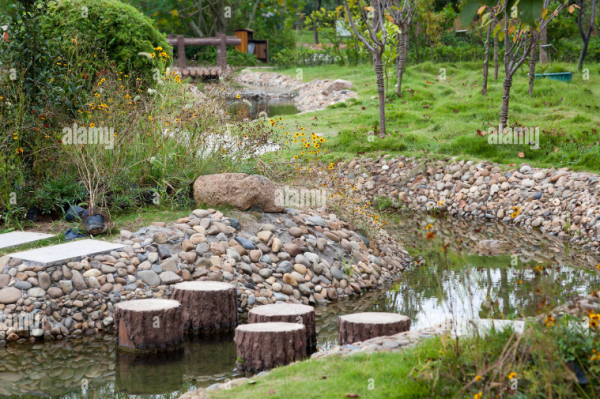 Taman dengan jalan setapak berbatu yang melintasi kolam mini